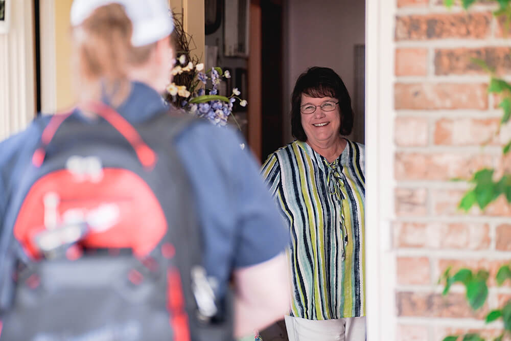 happy customer greeting a woman service tech at the front door
