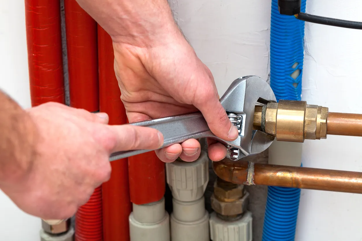 A person using tool repairing a gas line pipe